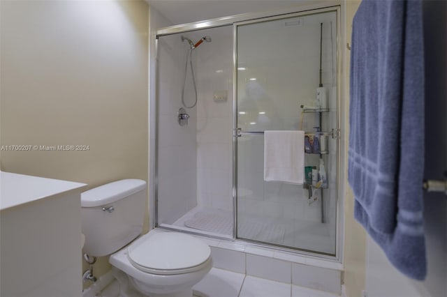 bathroom with tile patterned floors, toilet, an enclosed shower, and vanity