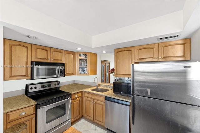 kitchen with sink, light tile patterned floors, and stainless steel appliances