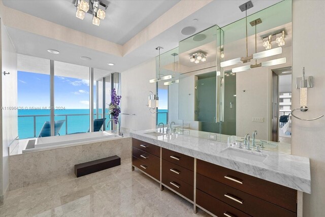 bathroom with vanity, a water view, a healthy amount of sunlight, and shower with separate bathtub