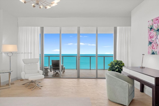 interior space with a water view, light wood-type flooring, and a chandelier