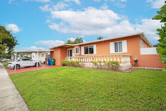 view of front facade with a carport and a front yard