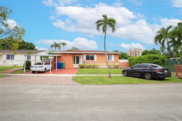 view of front of home with a carport and a front lawn