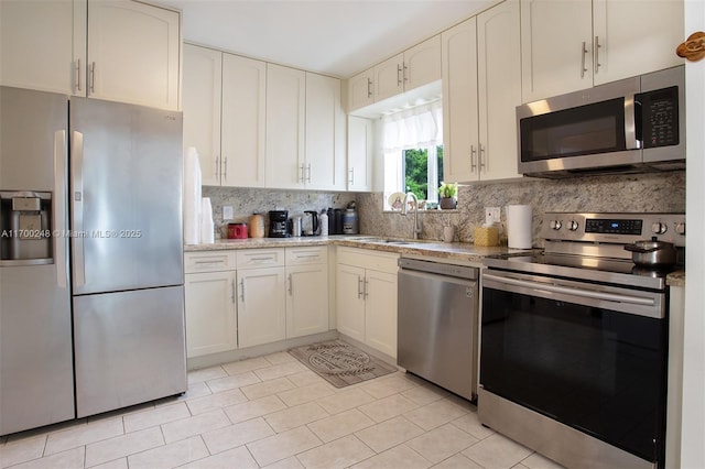 kitchen with tasteful backsplash, stainless steel appliances, a sink, and light countertops