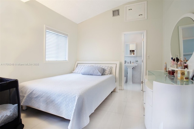 bedroom with lofted ceiling, light tile patterned floors, a sink, and visible vents