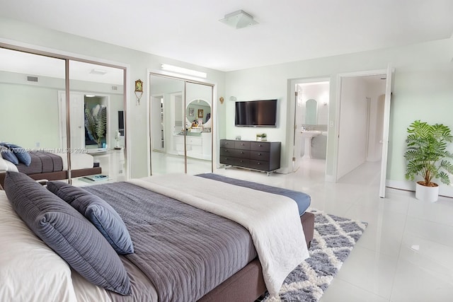 tiled bedroom featuring ensuite bath and visible vents