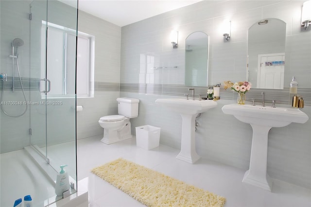 full bath featuring a stall shower, tile walls, toilet, and tile patterned floors