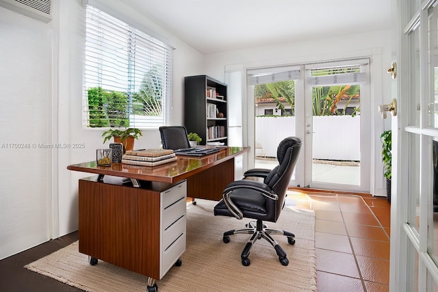 office featuring a wall unit AC, light tile patterned flooring, and french doors