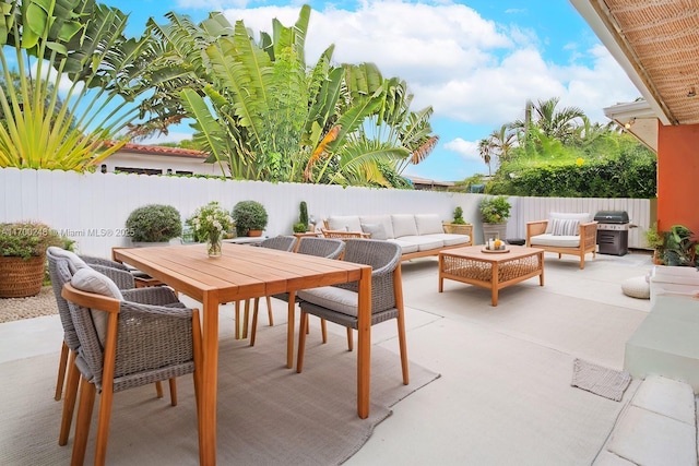 view of patio / terrace with outdoor dining space, a fenced backyard, grilling area, and an outdoor hangout area