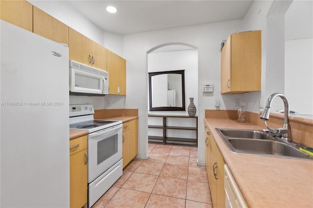 kitchen featuring white appliances, sink, and light tile patterned floors