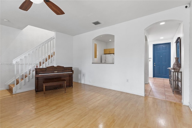 living room with ceiling fan and light wood-type flooring