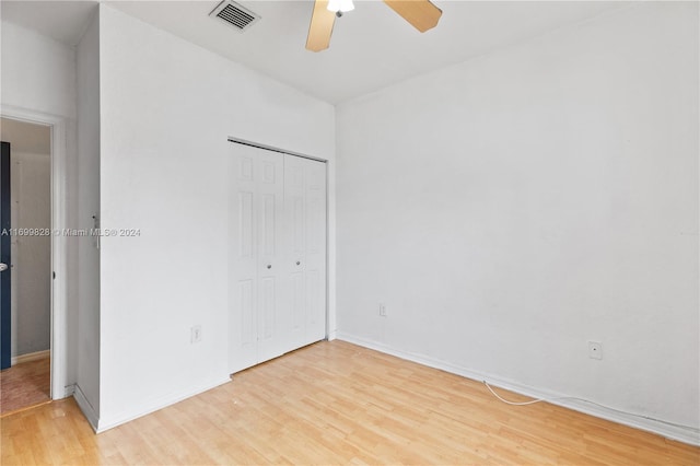 unfurnished bedroom with a closet, light hardwood / wood-style floors, and ceiling fan