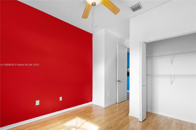 unfurnished bedroom featuring ceiling fan, wood-type flooring, and a closet