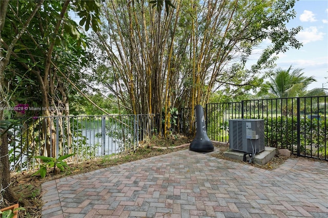 view of patio featuring a water view and central air condition unit