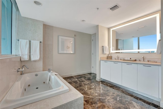 bathroom featuring vanity and tiled tub