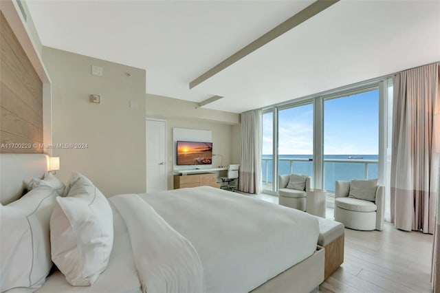 bedroom featuring expansive windows and light wood-type flooring