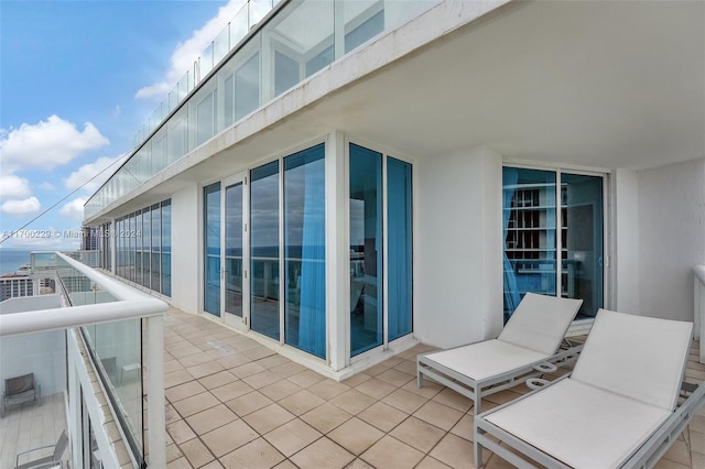 view of patio featuring a balcony and a water view