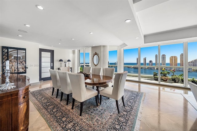 dining room with a water view and light tile patterned floors