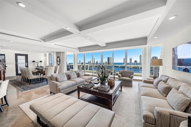 living room with beam ceiling, a water view, and coffered ceiling