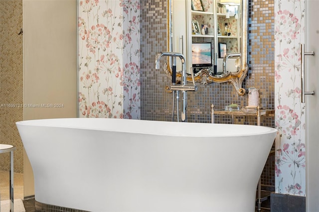 bathroom featuring a tub to relax in and tile walls