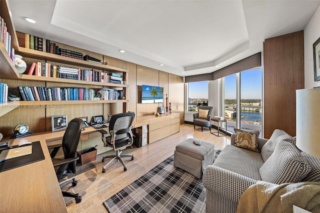 office area featuring a tray ceiling and hardwood / wood-style floors