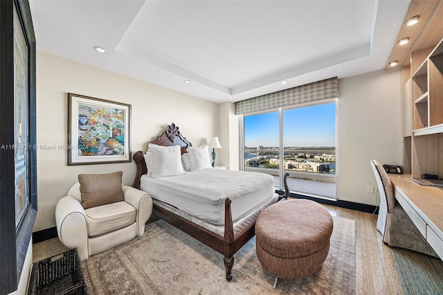 bedroom featuring a raised ceiling and hardwood / wood-style flooring