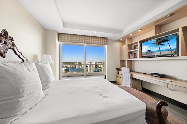 bedroom featuring hardwood / wood-style flooring and a tray ceiling