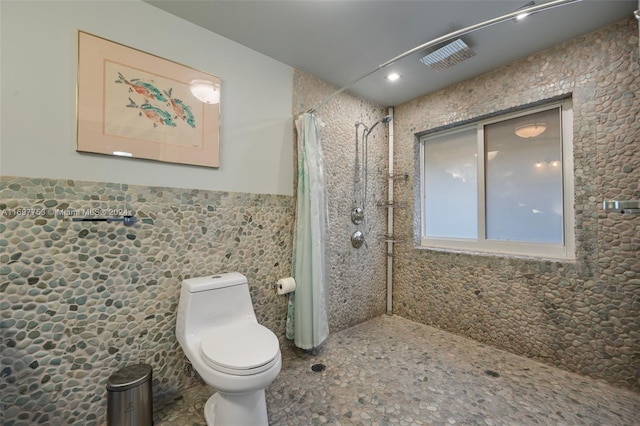 bathroom with toilet, tile walls, and a shower with shower curtain