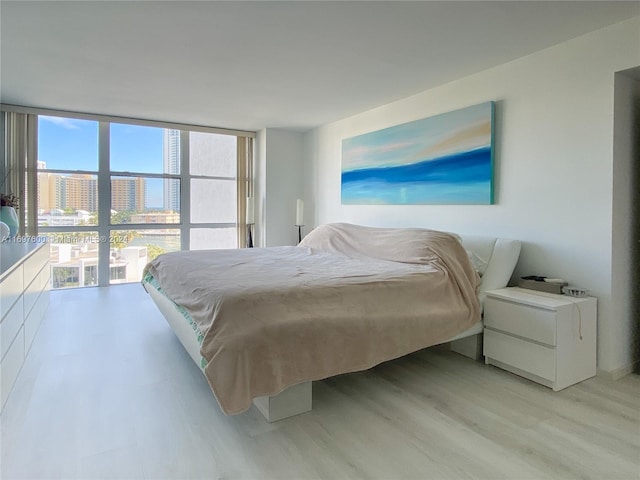 bedroom with light hardwood / wood-style flooring and a wall of windows