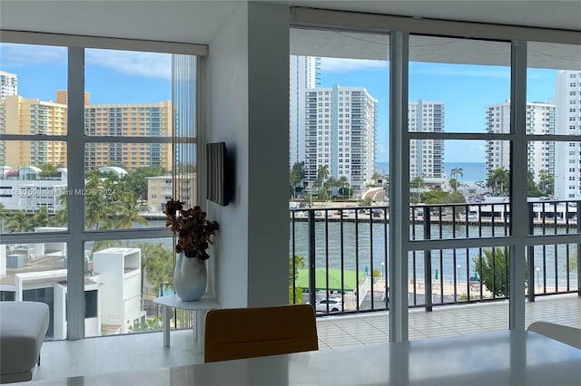 doorway to outside featuring light tile patterned floors, a water view, and a wall of windows