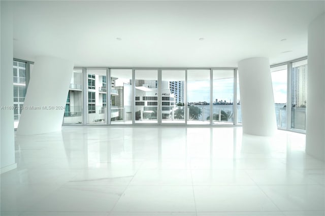 empty room featuring expansive windows and light tile patterned flooring