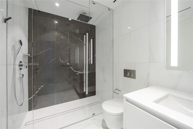 bathroom with tiled shower, vanity, and toilet