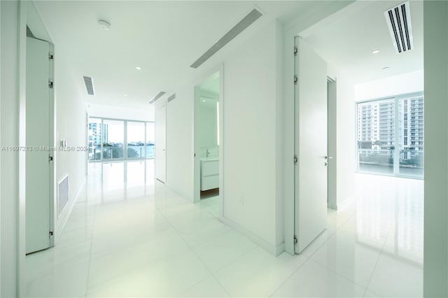 corridor featuring plenty of natural light and light tile patterned floors