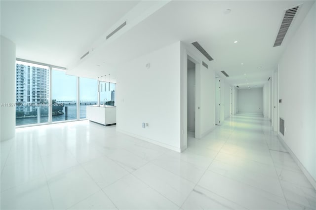 hall with floor to ceiling windows and a water view