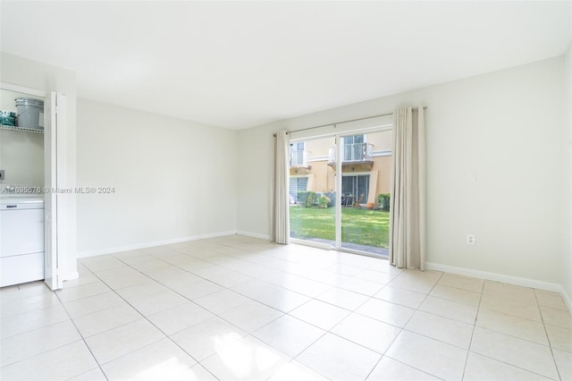 unfurnished room with washer / clothes dryer and light tile patterned flooring