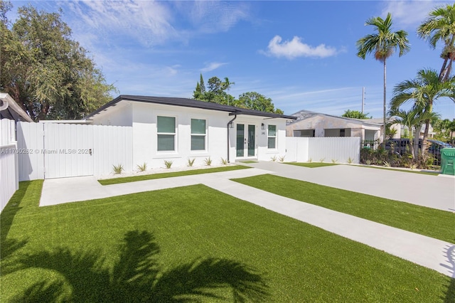 view of front of property featuring french doors and a front lawn