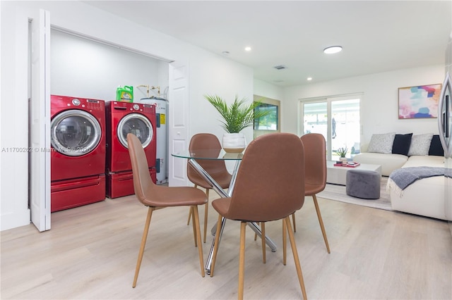 dining room with light wood-type flooring and separate washer and dryer