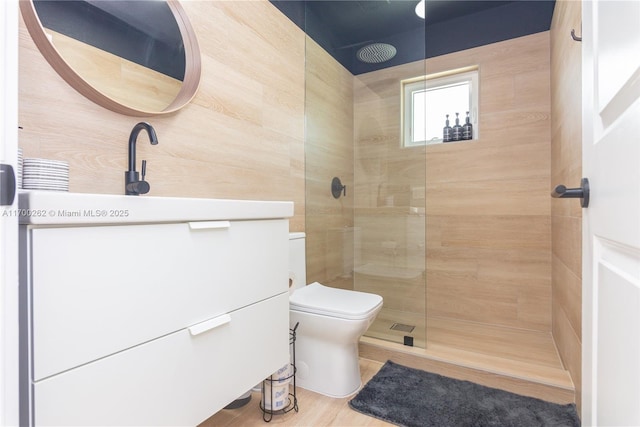 bathroom featuring tiled shower, wood-type flooring, and toilet