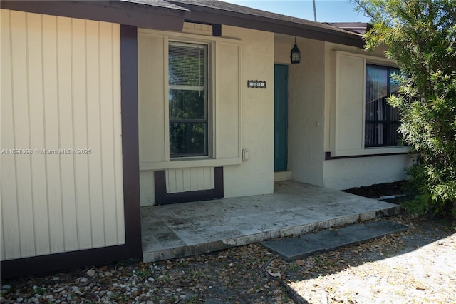 view of exterior entry featuring a shingled roof