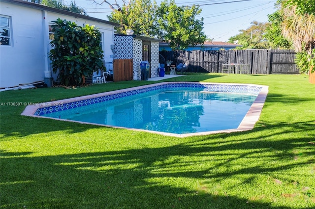 view of swimming pool featuring fence, a fenced in pool, and a yard