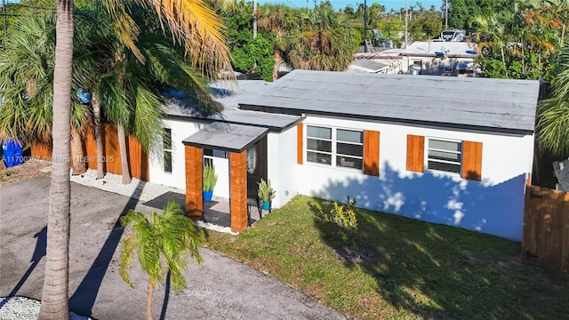 view of front of property with driveway, a front lawn, and fence