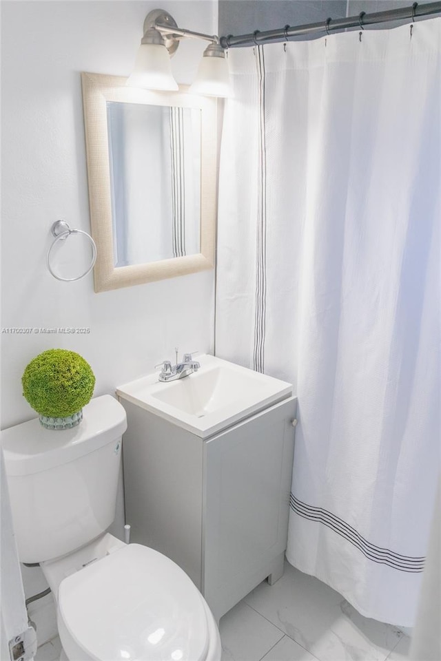 bathroom featuring toilet, a shower with curtain, and vanity