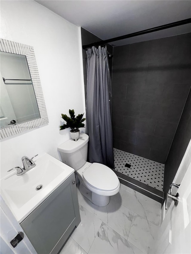 bathroom with walk in shower, vanity, and toilet