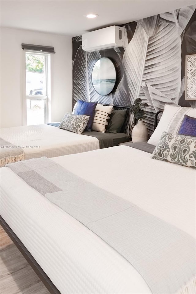 bedroom featuring hardwood / wood-style flooring and a wall unit AC