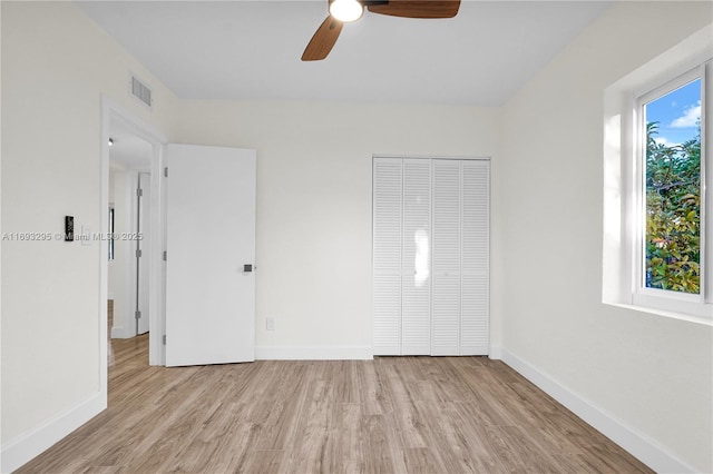 unfurnished bedroom with ceiling fan, a closet, and light wood-type flooring