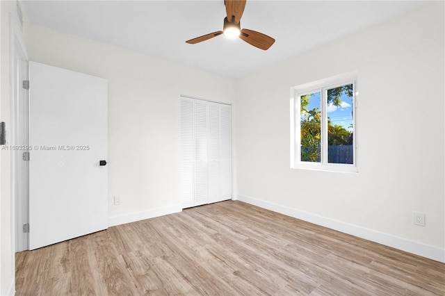 spare room featuring a ceiling fan, baseboards, and wood finished floors