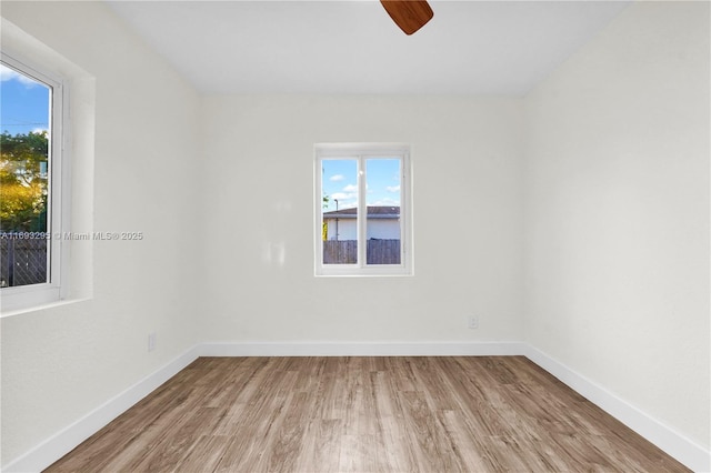 spare room featuring baseboards, ceiling fan, and wood finished floors