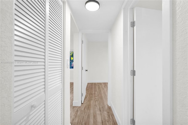 corridor with light hardwood / wood-style floors