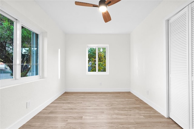 unfurnished bedroom with multiple windows, a closet, light hardwood / wood-style flooring, and ceiling fan