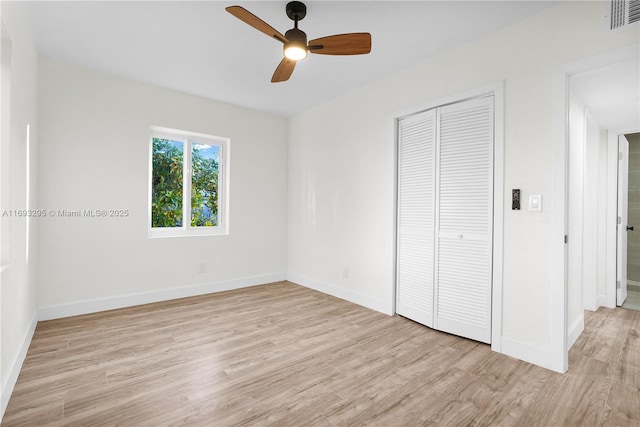 unfurnished bedroom with a closet, light hardwood / wood-style floors, and ceiling fan