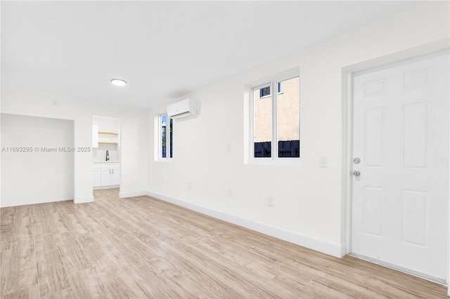 interior space with light hardwood / wood-style floors and a wall mounted AC